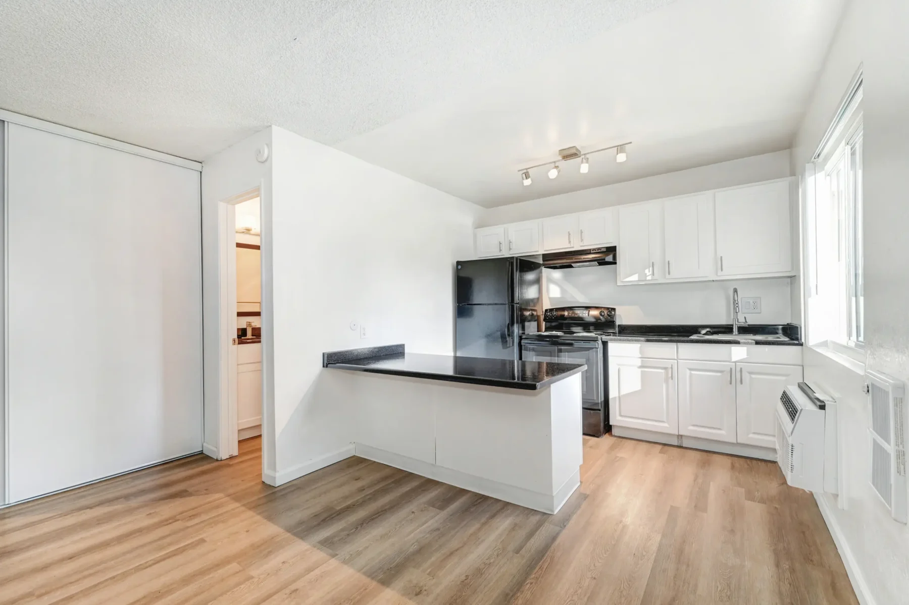 Kitchen with breakfast bar seating, black countertops and black appliances