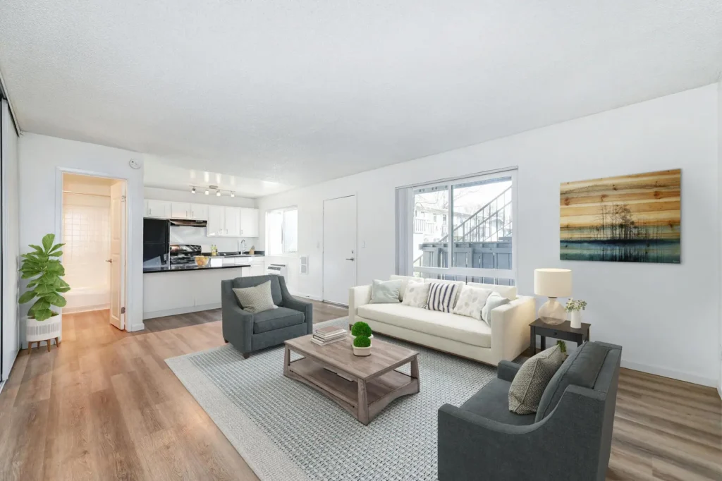 Staged model living room with large windows and open kitchen