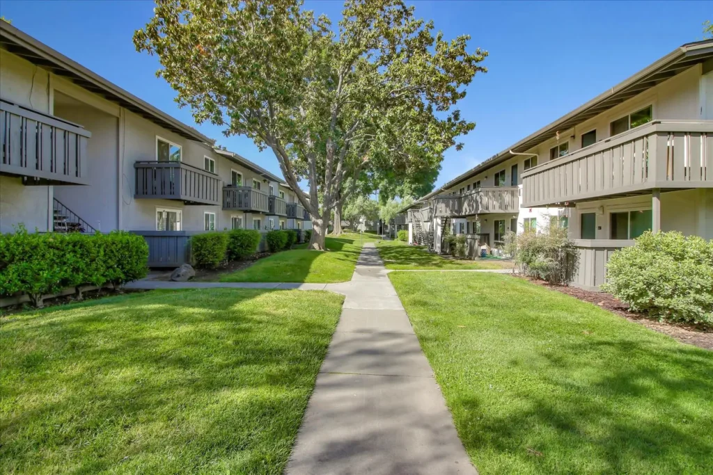 Sidewalk leading between buildings with trees