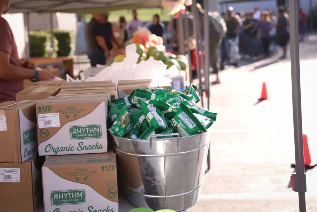 Vendor at an outdoor market selling bags of Organic Snacks
